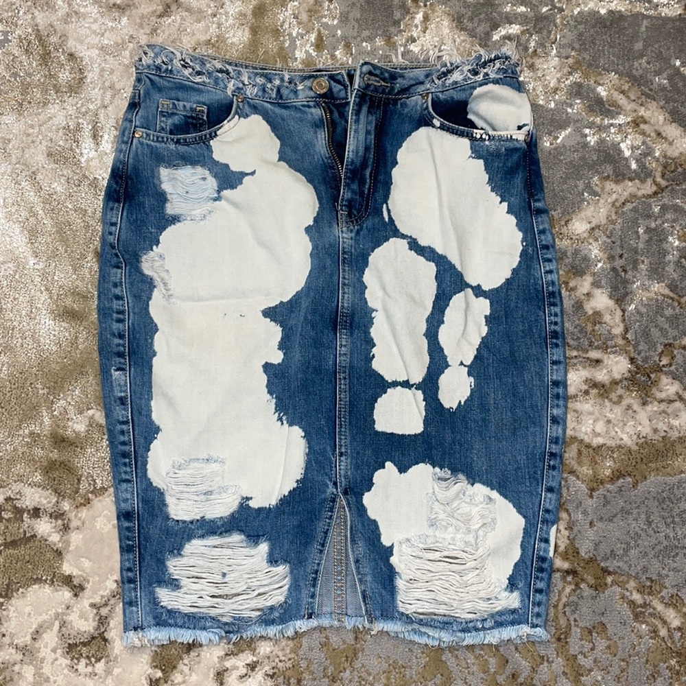 Acid wash distressed denim skirt with slit in the front.